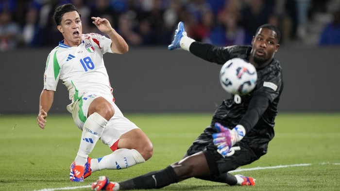 Italys Giacomo Raspadori scores his sides third goal past France goalkeeper Mike Maignan during the UEFA Nations League soccer match between France and Italy at the Parc des Princes in Paris, Friday, Sept. 6, 2024. (AP Photo/Michel Euler)