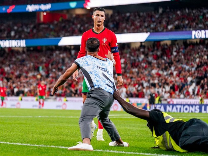 LISBON, PORTUGAL - SEPTEMBER 08: A pitch invader tries to get through to Cristiano Ronaldo of Portugal during the UEFA Nations League 2024/25 League A Group A1 match between Portugal and Scotland at Estadio do SL Benfica on September 8, 2024 in Lisbon, Portugal. (Photo by Rene Nijhuis/MB Media/Getty Images)