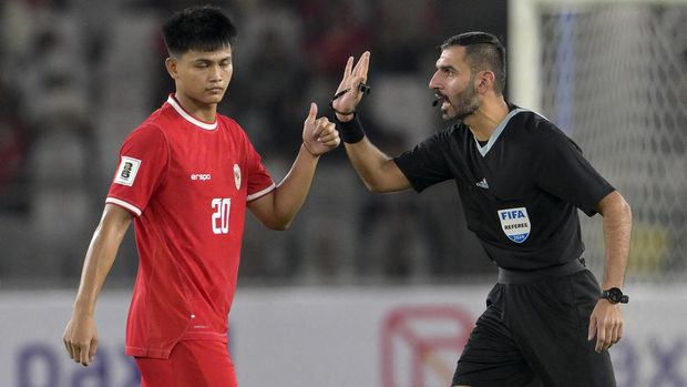 Qatar referee Salman Ahmad Falahi (R) warns to Indonesia's player Hokky Caraka Brilliant during the 2026 FIFA World qualifier football match between Indonesia and Vietnam at the Bung Karno Stadium in Jakarta on November 21, 2024. (Photo by BAY ISMOYO / AFP)