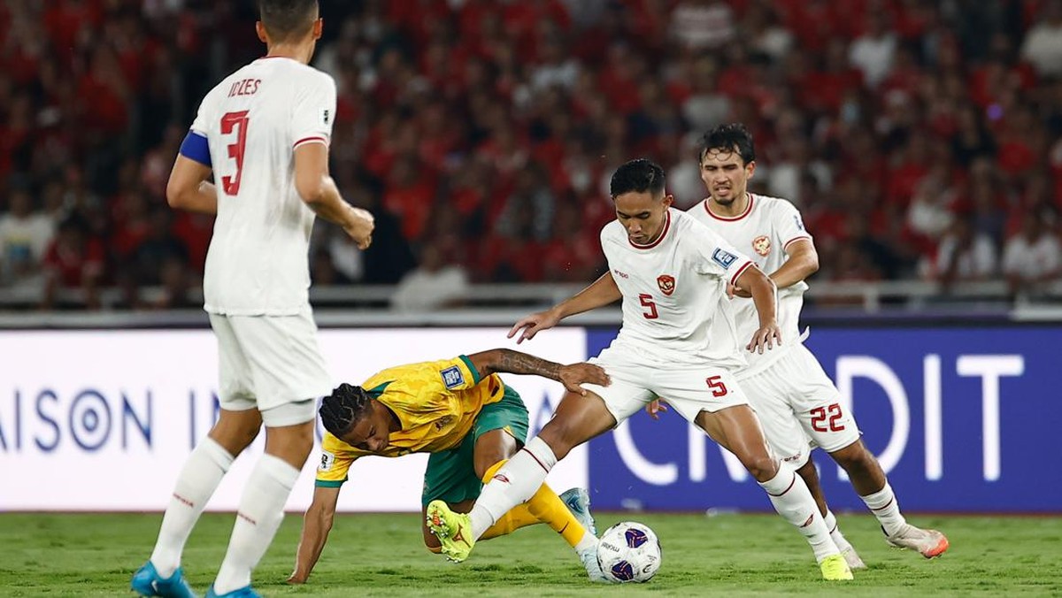 Momen Rizky Ridho menang duel perebutan bola dengan pemain Australia. (Foto: Getty Images/Robertus Pudyanto)
