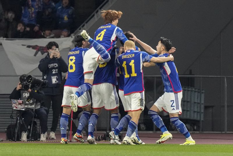 Japan's players celebrates scoring their first goal during the FIFA World Cup 2026 and AFC Asian Cup 2027 preliminary joint qualification round 2 match between Japan and North Korea at the National Stadium Thursday, March 21, 2024, in Tokyo. (AP Photo/Eugene Hoshiko)