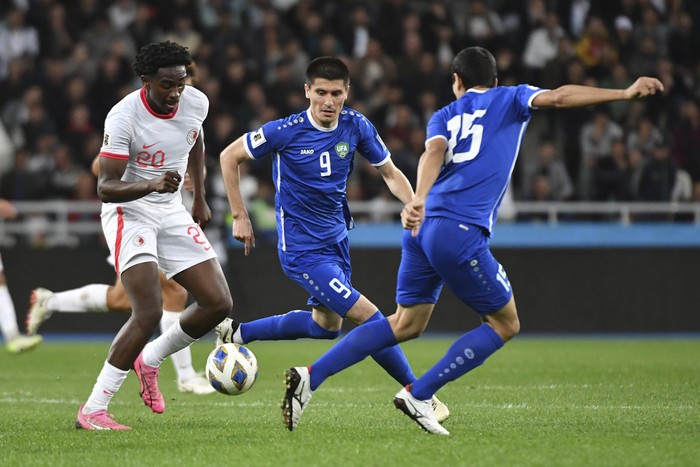 Hong Kongs Michael Udebuluzor, left, challenges for the ball with Uzbekistans Umar Eshmurodov, right, and Uzbekistans Odildzhon Khamrobekov during the second round of the Asian qualifier group E soccer match for 2026 FIFA World Cup between Uzbekistan and Hong Kong at the Bunyodkor stadium in Tashkent, Uzbekistan, Tuesday, March 26, 2024. (AP Photo)