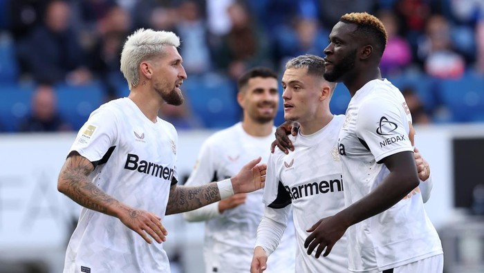 SINSHEIM, GERMANY - SEPTEMBER 14: Florian Wirtz of Bayer 04 Leverkusen celebrates scoring his teams third goal from the penalty spot with team mates Robert Andrich and Victor Boniface of Bayer 04 Leverkusen during the Bundesliga match between TSG 1899 Hoffenheim and Bayer 04 Leverkusen at PreZero-Arena on September 14, 2024 in Sinsheim, Germany. (Photo by Alex Grimm/Getty Images)