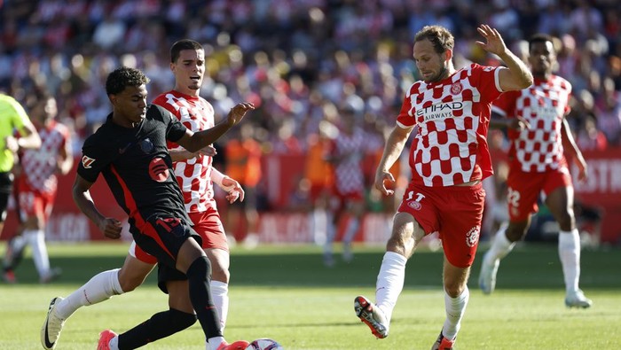 Barcelonas Lamine Yamal, left, challenges for the ball with Gironas Miguel Gutierrez, centre, and Gironas Daley Blind during the Spanish La Liga soccer match between Girona and Barcelona at the Montilivi stadium in Girona, Spain, Sunday, Sept. 15, 2024. (AP Photo/Joan Monfort)