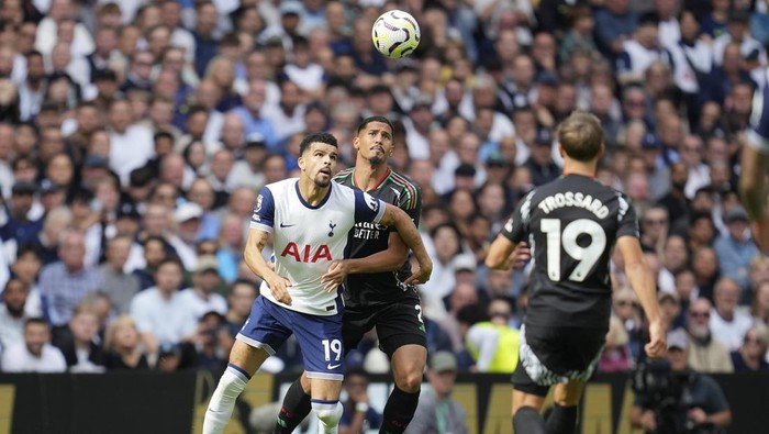 Arsenals William Saliba, center, challenges Tottenhams Dominic Solanke, left, during the English Premier League soccer match between Tottenham Hotspur and Arsenal in London, Sunday, Sept. 15, 2024. (AP Photo/Kin Cheung)