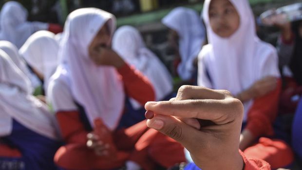 Siswa SMP Negeri 20 Tasikmalaya menunjukan tablet tambah darah saat gerakan aksi bergizi serentak di Kawalu, Kota Tasikmalaya, Jawa Barat, Senin (12/12/2024). Kegiatan yang digelar Dinas Kesehatan Kota Tasikmalaya dengan sarapan bergizi seimbang dan pemberian tablet tambah darah itu sebagai pencegahan stunting di usia remaja. ANTARA FOTO/Adeng Bustomi