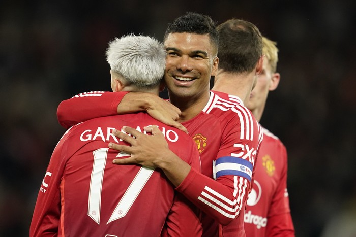 Manchester Uniteds Alejandro Garnacho is celebrated by Manchester Uniteds Casemiro after scoring his sides fourth goal during the English League Cup soccer match between Manchester United and Barnsley at Old Trafford, Manchester, England, Tuesday, Sept. 17, 2024. (AP Photo/Dave Thompson)