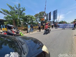 Aksi Polisi Ingatkan Pengendara Tak Terobos Palang KA di Jombang