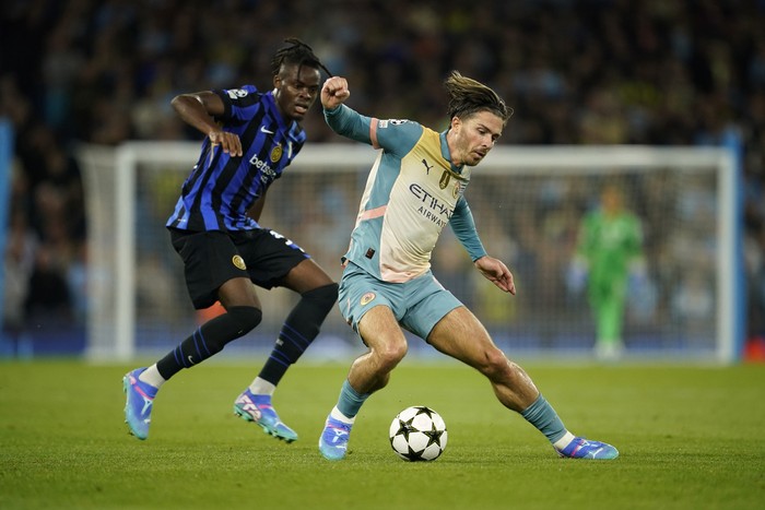 Manchester Citys Jack Grealish, right, is challenged by Inter Milans Yann Bisseck during the Champions League opening phase soccer match between Manchester City and Inter Milan at the Etihad Stadium, in Manchester, England, Wednesday, Sept. 18, 2024. (AP Photo/Dave Thompson)