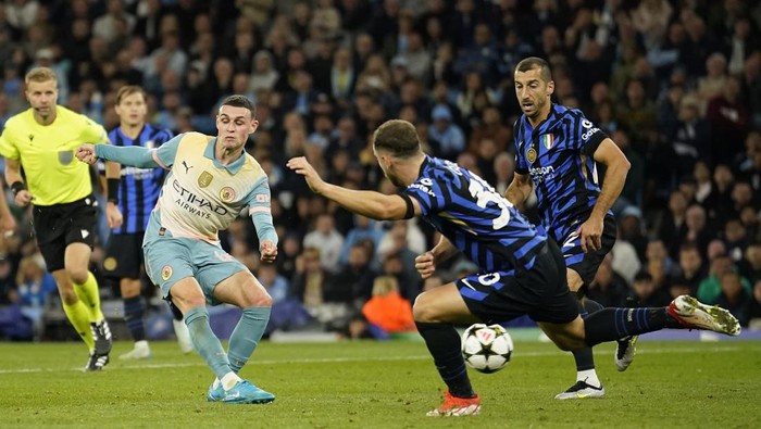 Manchester Citys Phil Foden, left, attempts a shot at goal in front of Inter Milans Matteo Darmian during the Champions League opening phase soccer match between Manchester City and Inter Milan at the Etihad Stadium, in Manchester, England, Wednesday, Sept. 18, 2024. (AP Photo/Dave Thompson)