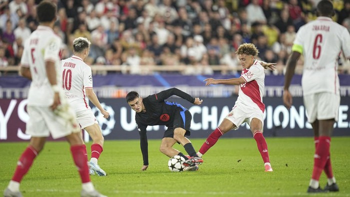Barcelonas Pedri, center, fights for the ball with Monacos Eliesse Ben Seghir during the Champions League opening phase soccer match between Monaco and Barcelona at the Louis II stadium, in Monaco, Monaco, Thursday, Sept. 19, 2024. (AP Photo/Laurent Cipriani)