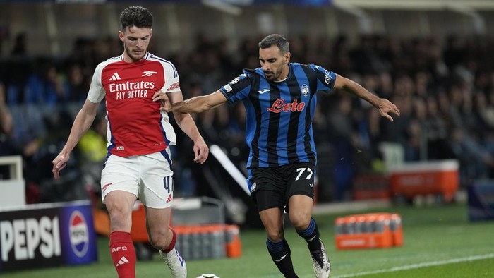 Arsenals Declan Rice, left, and Atalantas Davide Zappacosta challenge for the ball during the Champions League opening phase soccer match between Atalanta and Arsenal at the Bergamos stadium in Bergamo, Italy, Thursday, Sept. 19, 2024. (AP Photo/Antonio Calanni)