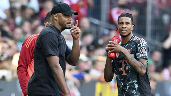 Munich's head coach Vincent Kompany, left, talks to Michael Olise, right, during the German Bundesliga soccer match between SV Werder Bremen and FC Bayern Munich in Bremen, Germany, Saturday, Sept. 21, 2024. (Carmen Jaspersen/dpa via AP)