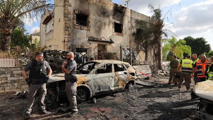 First responders and Israeli security forces gather amid debris and charred vehicles in Kiryat Bialik in the Haifa district of Israel, following a reported strike by Lebanons Hezbollah on September 22, 2024. Hezbollah said on September 22 that it targeted military production facilities and an air base near north Israels Haifa after the Israeli military pounded south Lebanon and said it targeted thousands of rocket launcher barrels. (Photo by Jack GUEZ / AFP)