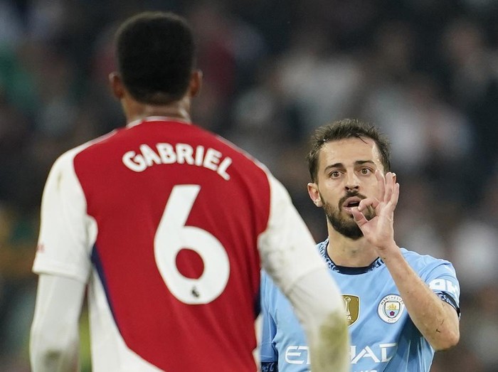 Manchester City's Bernardo Silva gestures at Arsenal's Gabriel during the English Premier League soccer match between Manchester City and Arsenal at the Etihad stadium in Manchester, England, Sunday, Sept. 22, 2024. (AP Photo/Dave Thompson)