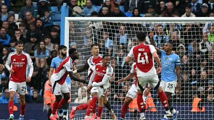 Arsenals Brazilian defender #06 Gabriel Magalhaes (C) celebrates scoring the teams second goal during the English Premier League football match between Manchester City and Arsenal at the Etihad Stadium in Manchester, north west England, on September 22, 2024. (Photo by Paul ELLIS / AFP) / RESTRICTED TO EDITORIAL USE. No use with unauthorized audio, video, data, fixture lists, club/league logos or live services. Online in-match use limited to 120 images. An additional 40 images may be used in extra time. No video emulation. Social media in-match use limited to 120 images. An additional 40 images may be used in extra time. No use in betting publications, games or single club/league/player publications. /