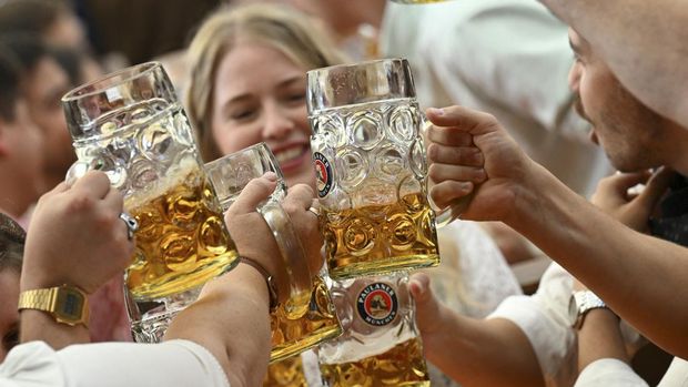 Guests toast with beer mugs on the day of the official opening of the 189th Oktoberfest, the world's largest beer festival in Munich, Germany, September 21, 2024. REUTERS/Angelika Warmuth