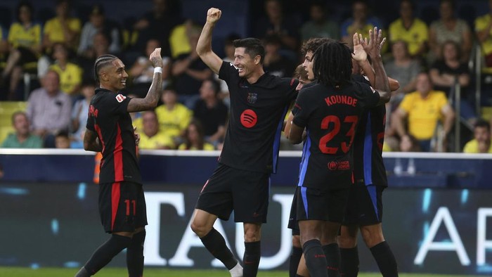 Barcelonas Robert Lewandowski, center, celebrates with teammates after he scoring his sides 2nd goal against Villarreal during a Spanish La Liga soccer match at the La Cerámica stadium in Villarreal, Spain, Sunday, Sept. 22, 2024. (AP Photo/Alberto Saiz)