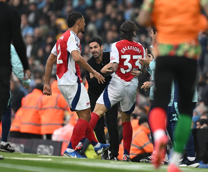 MANCHESTER, ENGLAND - SEPTEMBER 22: Riccardo Calafiori celebrates scoring Arsenals 1st goal with Arsenal Manager Mikel Arteta during the Premier League match between Manchester City FC and Arsenal FC at Etihad Stadium on September 22, 2024 in Manchester, England. (Photo by David Price/Arsenal FC via Getty Images)