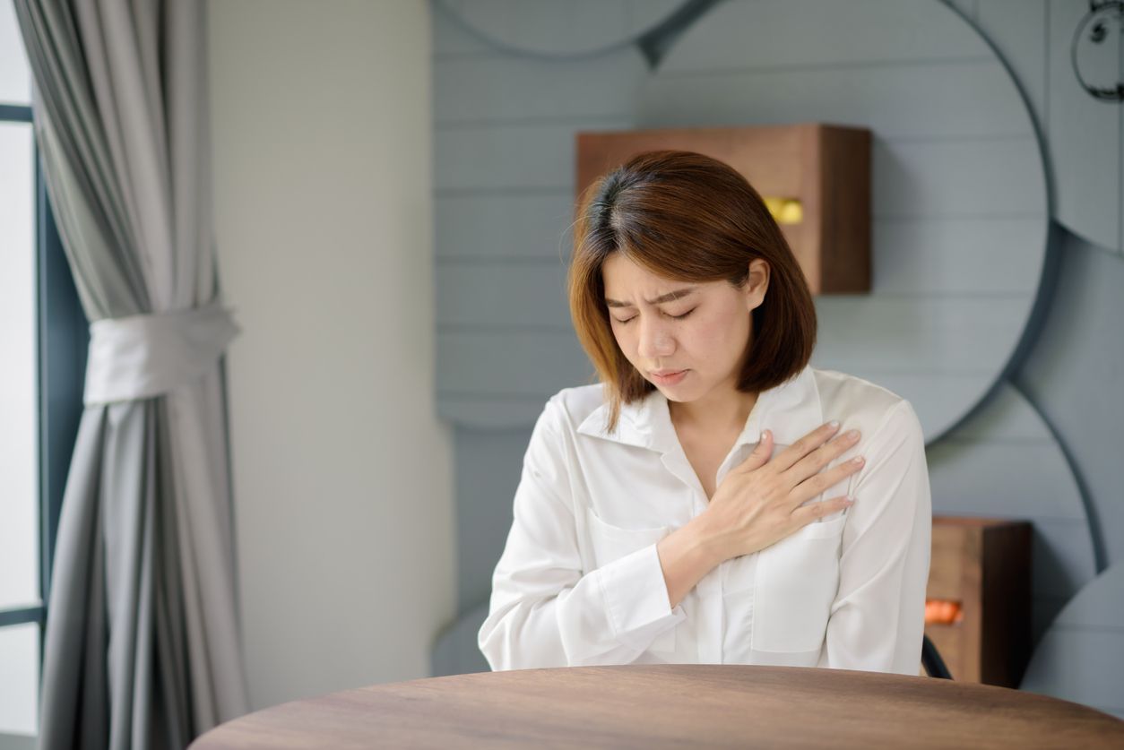 An Asian woman clutched her chest due to suffering from a sudden heart attack.