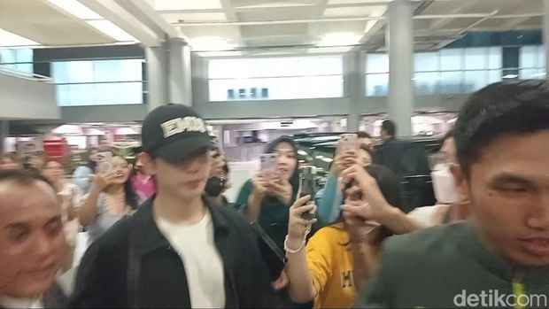 Jung Hae In (topi hitam) dan Kim Yoon Ji alias Jung So Min mendarat di Bandara Internasional Ngurah Rai, Selasa (24/9/2024), sekira pukul 23.10 Wita. (Aryo Mahendro/detikBali).