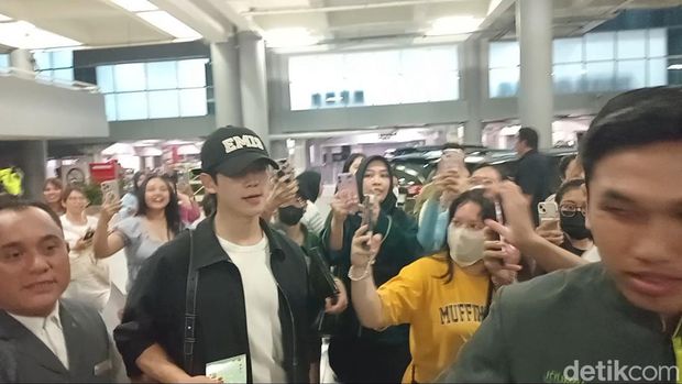 Jung Hae In (topi hitam) dan Kim Yoon Ji alias Jung So Min mendarat di Bandara Internasional Ngurah Rai, Selasa (24/9/2024), sekira pukul 23.10 Wita. (Aryo Mahendro/detikBali).