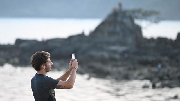 Wisatawan memotret dengan gawainya di Pantai Kuta Mandalika, Lombok Tengah, NTB, Rabu (25/9/2024). Kemenparekraf memperkirakan adanya pergerakan hingga 102 ribu wisatawan di Mandalika dimana 12 hingga 15 persennya adalah wisatawan mancanegara karena adanya perhelatan balap motor MotoGP. ANTARA FOTO/Akbar Nugroho Gumay/nz