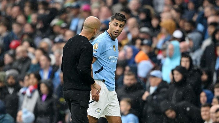 MANCHESTER, ENGLAND - SEPTEMBER 22: Rodri of Manchester City talks to Josep Guardiola, Manager of Manchester City, after leaving the pitch due to an injury during the Premier League match between Manchester City FC and Arsenal FC at Etihad Stadium on September 22, 2024 in Manchester, England. (Photo by Michael Regan/Getty Images)