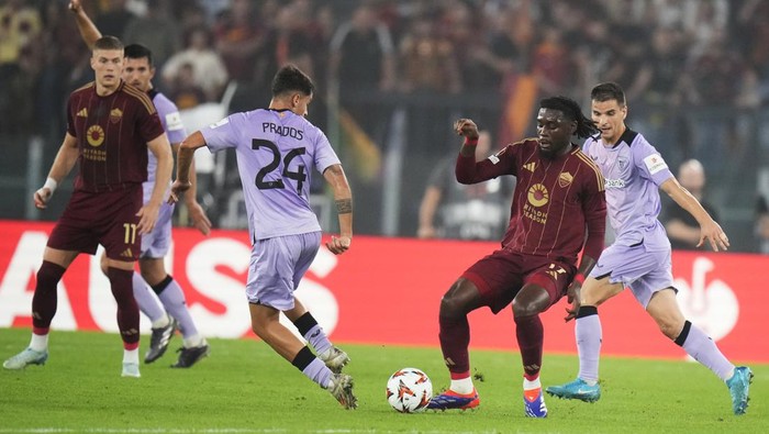 Romas Manu Kone, centre right, and Athletic Bilbaos Benat Prados, centre left, challenge for the ball during the Europa League opening phase soccer match between Roma and Athletic Club at the Stadio Olimpico in Rome, Italy, Thursday, Sept. 26, 2024. (AP Photo/Alessandra Tarantino)