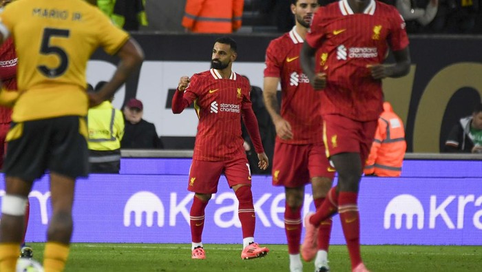 Liverpools Mohamed Salah, center, celebrates scoring his sides 2nd goal from the penalty spot during the English Premier League soccer match between Wolverhampton Wanderers and Liverpool at the Molineux Stadium in Wolverhampton, England, Saturday, Sept. 28, 2024. (AP Photo/Rui Vieira)