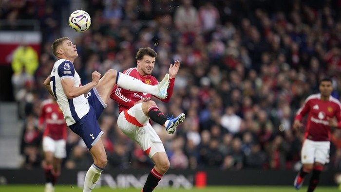 Tottenhams Micky van de Ven, left, challenges for the ball with Manchester Uniteds Mason Mount during the English Premier League soccer match between Manchester United and Tottenham Hotspur at Old Trafford stadium in Manchester, England, Sunday, Sept. 29, 2024. (AP Photo/Dave Thompson)