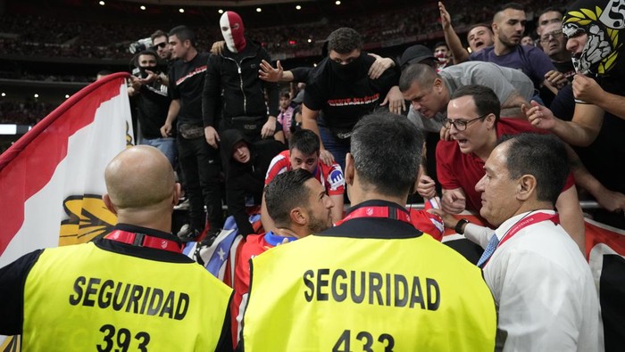 Atletico Madrids Koke asks fans to stop throwing objects on the pitch, as the play was suspended during the La Liga soccer match between Atletico Madrid and Real Madrid at the Metropolitano stadium in Madrid, Spain, Sunday, Sept. 29, 2024. (AP Photo/Bernat Armangue)