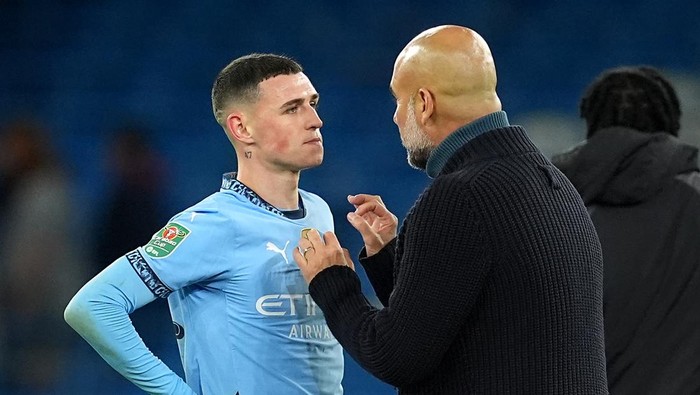 Manchester Citys Phil Foden and manager Pep Guardiola after the Carabao Cup third round match at the Etihad Stadium, Manchester. Picture date: Tuesday September 24, 2024. (Photo by Martin Rickett/PA Images via Getty Images)