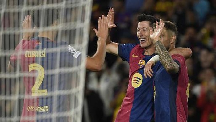 Barcelonas Polish forward #09 Robert Lewandowski (2R) celebrates with teammates scoring his teams fourth goal during the UEFA Champions League, league phase day 2 football match between FC Barcelona and Young Boys at the Estadi Olimpic Lluis Companys in Barcelona on October 1, 2024. (Photo by Josep LAGO / AFP)