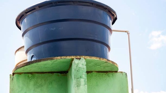 Ilustrasi tandon air atau toren air di rumah. Blue plastic water tank used in residential constructions in Brazil