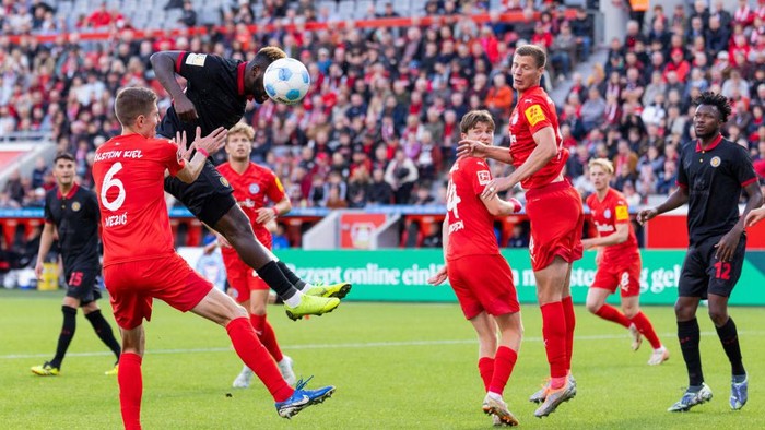05 October 2024, North Rhine-Westphalia, Leverkusen: Soccer: Bundesliga, Bayer Leverkusen - Holstein Kiel, Matchday 6, BayArena. Leverkusens Victor Boniface (2nd from left) gets the ball in front of Kiels Marko Ivezic. Photo: Rolf Vennenbernd/dpa - IMPORTANT NOTE: In accordance with the regulations of the DFL German Football League and the DFB German Football Association, it is prohibited to utilize or have utilized photographs taken in the stadium and/or of the match in the form of sequential images and/or video-like photo series. (Photo by Rolf Vennenbernd/picture alliance via Getty Images)