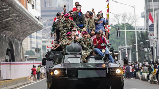 Pawai alutsista hari ini digelar dalam rangka memperingati HUT ke-79 TNI. Warga tampak berfoto di atas tank TNI saat pawai itu berlangsung.