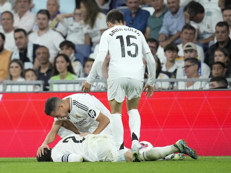 Real Madrid's Lucas Vazquez checks on his teammate Dani Carvajal during the La Liga soccer match between Real Madrid and Villareal in Madrid, Spain, on Saturday, Oct. 5, 2024. (AP Photo/Bernat Armangue)