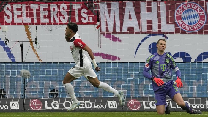 Frankfurts Omar Marmoush, centre, celebrates after scoring his sides first goal past Bayerns goalkeeper Manuel Neuer during the German Bundesliga soccer match between Eintracht Frankfurt and Bayern Munich in Frankfurt, Germany, Sunday, Oct. 6, 2024. (AP Photo/Michael Probst)