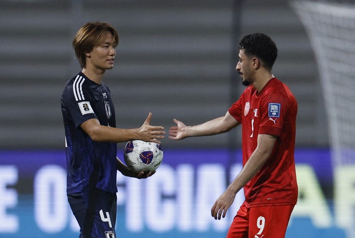 Soccer Football - World Cup - AFC Qualifiers - Group C - Bahrain v Japan - Bahrain National Stadium, Riffa, Bahrain - September 10, 2024 Japans Kou Itakura shakes hands with Bahrains Husain Abdulkarim after the match REUTERS/Hamad I Mohammed