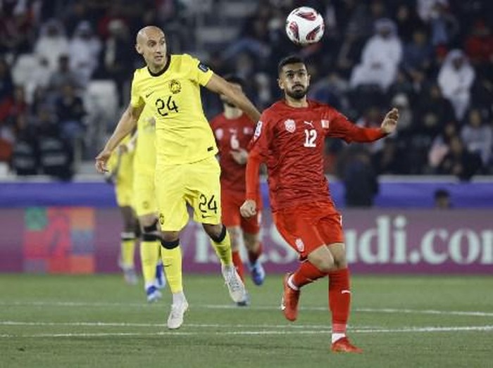 Malaysias midfielder #24 Natxo Insa and Bahrains midfielder #12 Ali Hassan vie for a header during the Qatar 2023 AFC Asian Cup Group E football match between Bahrain and Malaysia at the Jassim bin Hamad Stadium in Doha on January 20, 2024. (Photo by KARIM JAAFAR / AFP)