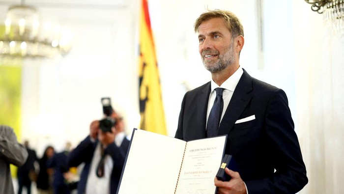 FILE PHOTO: Former FC Liverpool manager Juergen Klopp poses with the Order of Merit of the Federal Republic of Germany at Bellevue Palace to mark the unification day in Berlin, October 1, 2024. REUTERS/Lisi Niesner/File Photo