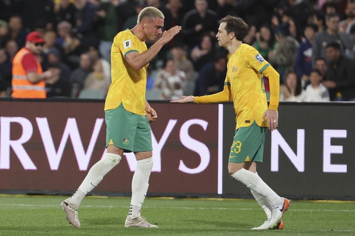 Australias Craig Goodwin, right, congratulates teammate Lewis Miller after scoring their teams first goal during the World Cup 2026 Group C qualifying soccer match between Australia and China at Adelaide Oval, Adelaide, Australia, Thursday Oct. 10, 2024. (AP Photo/James Elsby)