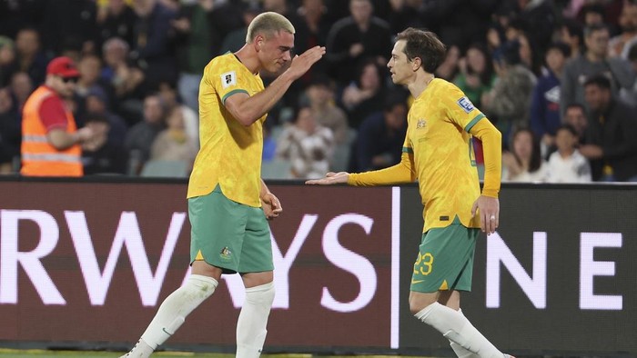 Australias Craig Goodwin, right, congratulates teammate Lewis Miller after scoring their teams first goal during the World Cup 2026 Group C qualifying soccer match between Australia and China at Adelaide Oval, Adelaide, Australia, Thursday Oct. 10, 2024. (AP Photo/James Elsby)