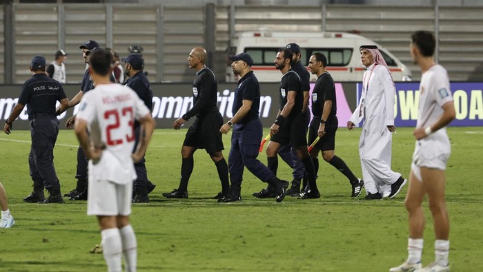 Soccer Football - World Cup - Asian Qualifiers - Third Round - Group C - Bahrain v Indonesia - Bahrain National Stadium, Riffa, Bahrain - October 10, 2024 Referee Ahmed Al-Kaf with police after the match REUTERS/Hamad I Mohammed