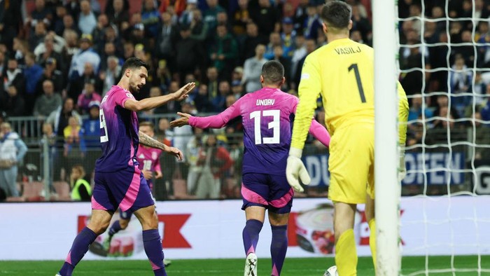 11 October 2024, Bosnia-Herzegovina, Zenica: Soccer, Nations League A, Bosnia-Herzegovina - Germany, Group stage, Group 3, Matchday 3, Stadion Bilino Polje, Germanys Deniz Undav (center) celebrates with Tim Kleindienst (left) after his second goal to make it 2-0, Bosnias goalkeeper Nikola Vasilj (right) looks on. Photo: Christian Charisius/dpa (Photo by Christian Charisius/picture alliance via Getty Images)