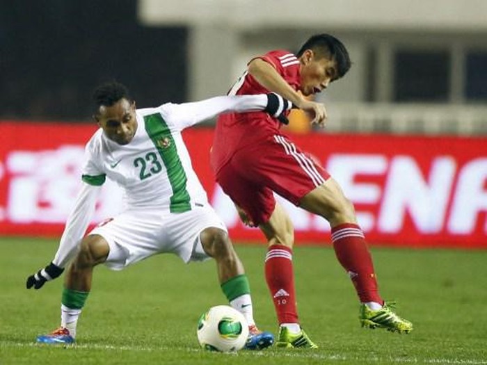 Huang Bowen (R) of China tussles for the ball against Titus Bonai of Indonesia during their 2015 Asian Cup group C qualifying football match in Xian, Chinas Shaanxi province on November 15, 2013. China beat Indonesia 1-0.    CHINA OUT         AFP PHOTO (Photo by AFP)