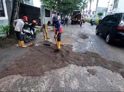 Jalan Opi Raya Palembang yang Rusak-Berlubang Ditambal dengan Pasir-Diaspal
