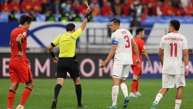 Soccer Football - World Cup - Asian Qualifiers - Third Round - Group C - China v Indonesia - Qingdao Youth Football Stadium, Qingdao, China - October 15, 2024 Indonesia's Jay Idzes is shown a yellow card by referee Omar Al Ali REUTERS/Florence Lo