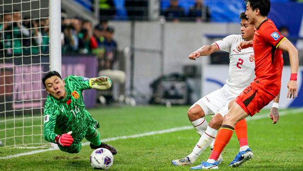 China's goalkeeper Wang Dalei (L) stops the ball during the 2026 FIFA World Cup Asian qualification football match between China and Indonesia at Qingdao, in eastern China's Shandong province on October 15, 2024. (Photo by AFP) / China OUT